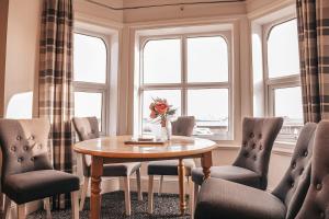 a dining room with a table and chairs and windows at STAYtastic in Lowestoft