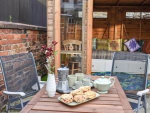 a wooden table with a plate of food on it at The Swiss Cottage in Pickering