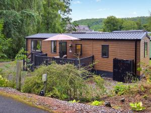 a small wooden cabin with an umbrella on a road at 1 Sunview Garden in Birnam