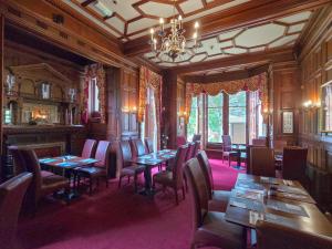 a dining room with tables and chairs and a chandelier at 1 Sunview Garden in Birnam