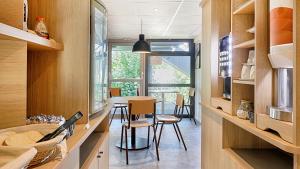 a kitchen and dining room with a table and chairs at Premiere Classe Dreux in Dreux