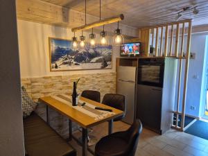 a dining room with a table and a refrigerator at Huber's Lodge in Hainzenberg