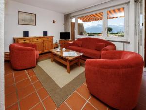 a living room with two red chairs and a table at Studio Terrasse Des Alpes 615 by Interhome in Vermala