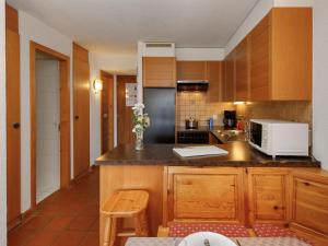 a kitchen with wooden cabinets and a counter top at Studio Terrasse Des Alpes 615 by Interhome in Vermala