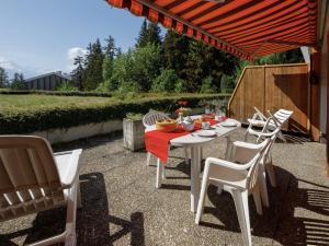 a white table and chairs on a patio at Studio Terrasse Des Alpes 615 by Interhome in Vermala