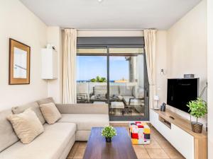 a living room with a couch and a tv at Apartment Alamar by Interhome in La Cala de Mijas