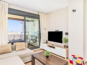 a living room with a couch and a flat screen tv at Apartment Alamar by Interhome in La Cala de Mijas +30 photos