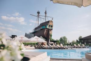 a pool with a pirate ship in the background at Bartolomeo in Dnipro