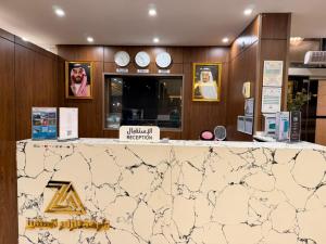 a marble counter in a store with clocks on the wall at Alzaer Almutamyez Ajyad in Mecca