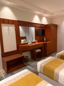 a hotel room with two beds and a desk at Alzaer Almutamyez Ajyad in Mecca +15 photos