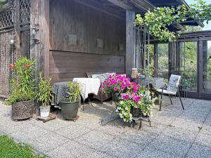 a patio with a table and chairs and flowers at Apartment Appartements Binderhof-1 by Interhome in Aschau