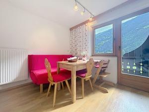 a dining room with a table and a red couch at Apartment Appartements Binderhof-1 by Interhome in Aschau