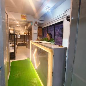 a woman sitting at a counter in a train car at Hotel My Home Dormitory in Boisar