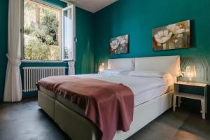 a bedroom with a large bed with a green wall at Villa Amatissima by Villa Porta Collection in Brezzo