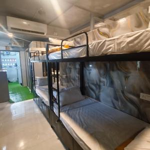 a group of bunk beds in a room at Hotel My Home Dormitory in Boisar +27 photos