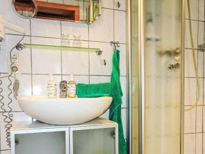 a bathroom with a sink and a green towel at Apartment FeWo Bärli by Interhome in Bad Bayersoien