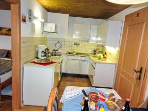 a small kitchen with white cabinets and a table at Apartment FeWo Bärli by Interhome in Bad Bayersoien