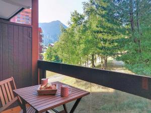 a wooden table with a bowl of fruit on a balcony at Apartment Pegase Phenix-65 by Interhome in Le Corbier