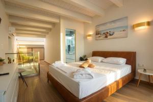 a bedroom with a large bed with white sheets at Villa Mare 2 - Private Pool, Sea View, Starlink, 4 Bdrms in Hanioti