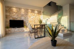 a dining room with a table and a stone wall at Villa Mare 2 - Private Pool, Sea View, Starlink, 4 Bdrms in Hanioti