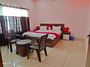 a bedroom with a bed and a table and chairs at Green Hotel in Jīnd