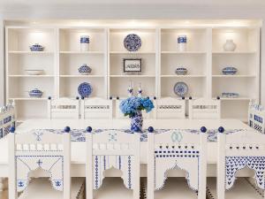 a white dining room with blue and white china at Fantastic 6B Villa in Sidi Daoud