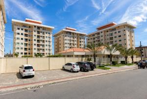 a row of apartment buildings with cars parked in a parking lot at Quarto Nômade Digital in Aracaju
