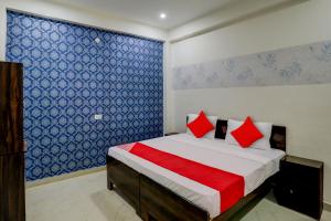 a bedroom with a large bed with red pillows at Hotel O The Raghav Villa in Prayagraj +34 photos