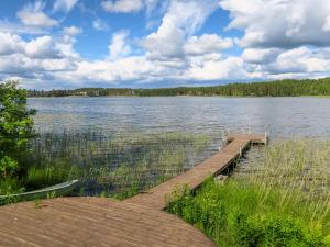 a dock on a lake with a boat on it at Holiday Home Suvela by Interhome in Kukkola