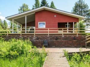 a red house with a porch and a deck at Holiday Home Suvela by Interhome in Kukkola