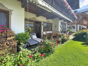 a porch of a house with a bench and flowers at Apartment Tyrol-1 by Interhome in Aschau