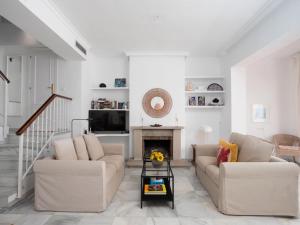 a living room with two couches and a fireplace at Holiday Home Sol de Estepona by Interhome in Estepona +35 photos