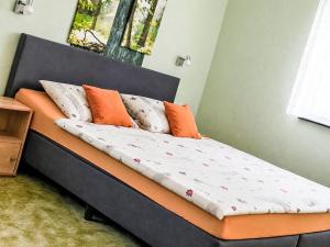 a bed with orange and white pillows on it at Apartment Siebers by Interhome in Sebnitz