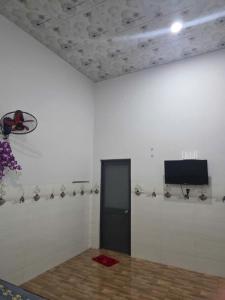 a room with a door and a tv on a wall at nhà nghỉ Thịnh Phát in Xóm Hương Phùng