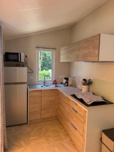 a kitchen with wooden cabinets and a sink and a window at Bahia 2 in Le Faulq