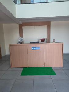 a reception desk in an office with a green rug at Hotel Nandanwan Resto and Bar in Mālsiras