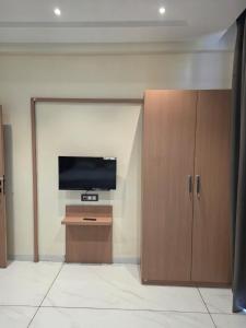 a living room with a television and a cabinet at Hotel Nandanwan Resto and Bar in Mālsiras