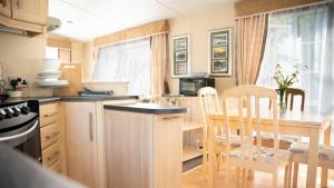a kitchen and dining room with a table and chairs at The Willows at Kingsmead Camping in West Buckland