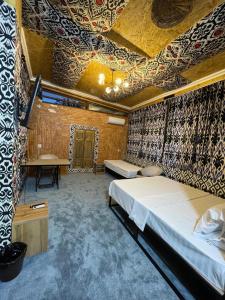 a bedroom with a large bed and a ceiling with patterns at Mulberry Hotel in Tashkent