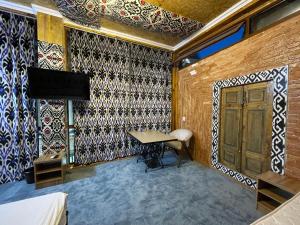 a room with a desk and a wall with a door at Mulberry Hotel in Tashkent