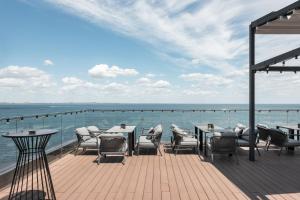 a deck with tables and chairs on the water at M1 Club Hotel in Odesa +66 photos