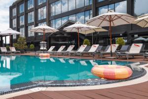 a swimming pool with chairs and umbrellas in a building at M1 Club Hotel in Odesa
