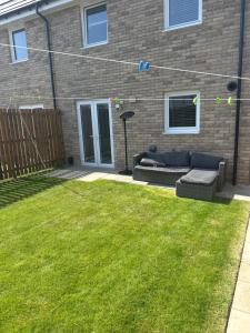 a backyard with a couch in the grass at House of Berry in EDI