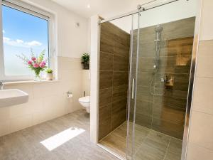 a bathroom with a shower and a toilet and a sink at Velmora Boutique Suites - Vintage Design Apartment in Altstadtnähe in Lübeck +32 photos