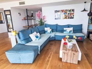 a blue couch in a living room with a table at Apartment New Beach-1 by Interhome in Roquebrune-Cap-Martin +22 photos