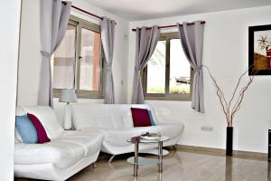 a white living room with a white couch and windows at Villa Saraliana Sandy Beach Villas - Heated Pool - Jacuzzi - Private Beach Area in Polis Chrysochous +33 photos