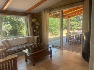 a living room with a couch and a table at Maison récente dans la nature in Roquebrune-sur-Argens