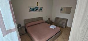 a small bedroom with a bed and two night stands at Petrucci House in Vasto