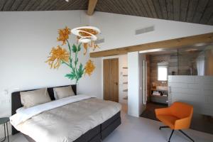 Roelofarendsveen阿尔赫特格尔夫住宿加早餐旅馆的一间卧室配有一张大床和一张橙色椅子