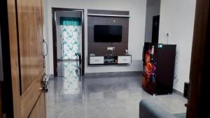 a living room with a television and a room with a door at Narayana Avenue , kondapur 2 Bhk in Hyderabad